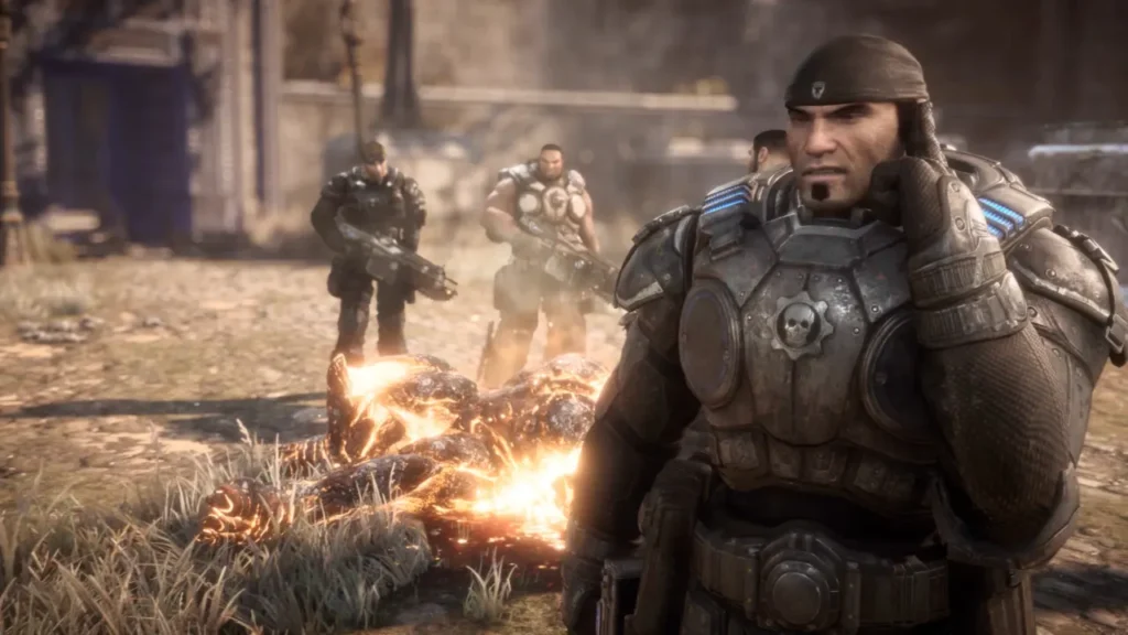 Gears of War Reloaded Squad Standing Over a Burning Enemy Corpse in Battle Armor - Is Gears of War Reloaded Crossplay?